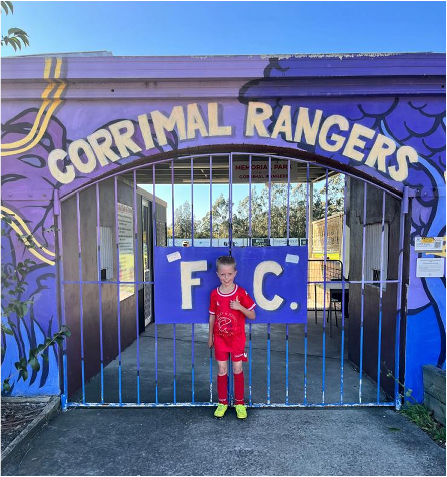 CRJSC Juniro Club Member standing in front of the Corrimal Ragers field gates